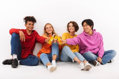 Neşeli Genç beyaz arka plan üzerinde izole gazlı içecekler ile toasting Grup