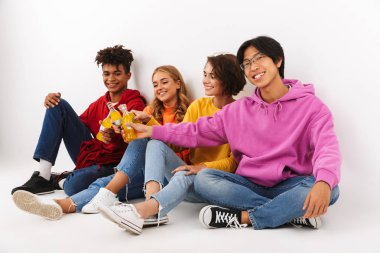 Neşeli Genç beyaz arka plan üzerinde izole gazlı içecekler ile toasting Grup