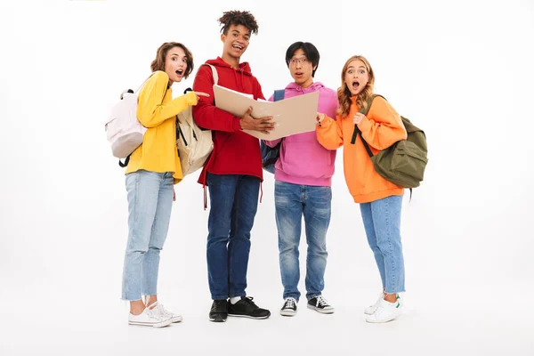 Группа Веселых Подростков Изолированы Белом Фоне Рюкзаками Глядя Открытую Папку — стоковое фото