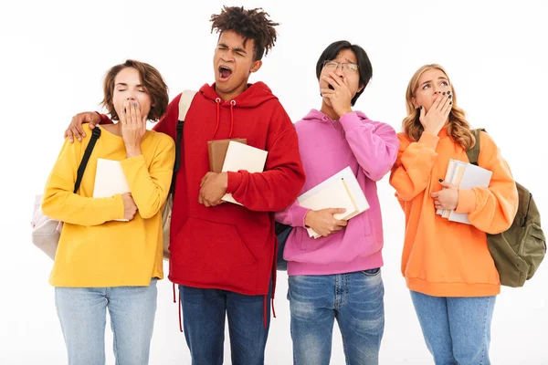 Yorgun genç grup izole arka plan beyaz duvar esneme üzerinde duran arkadaşları öğrencinin fotoğrafı.