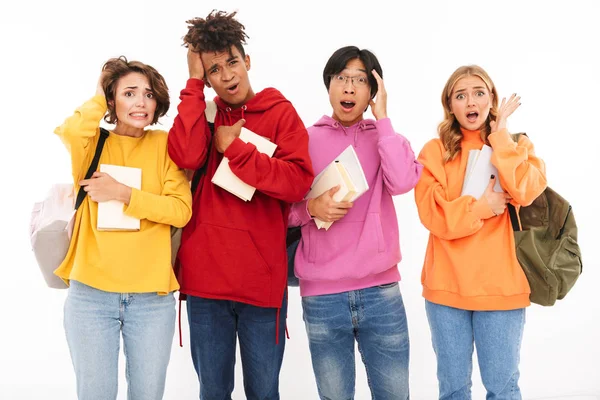 Beyaz duvar arka plan üzerinde izole ayakta arkadaşlar öğrenciler karışık şok genç grup görüntü.