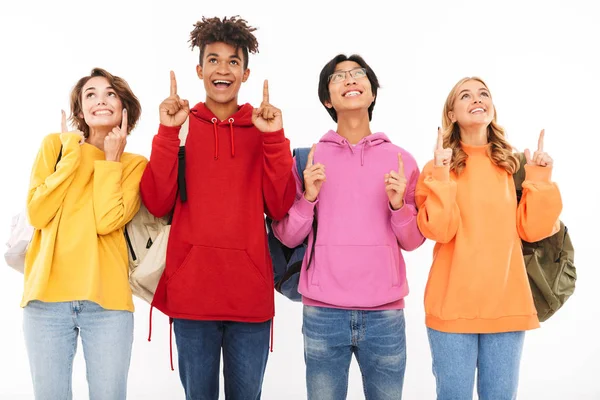 Grupo Adolescentes Alegres Isolados Sobre Fundo Branco Carregando Mochilas Apontando — Fotografia de Stock