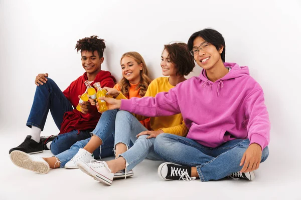 Neşeli Genç beyaz arka plan üzerinde izole gazlı içecekler ile toasting Grup