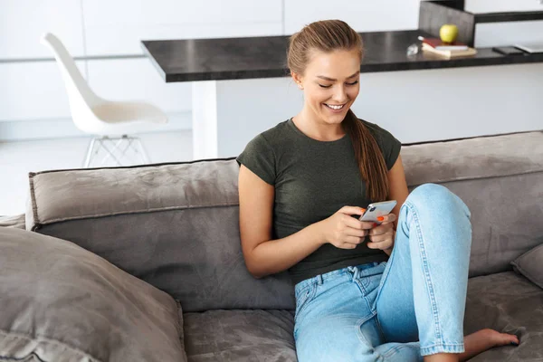 Fröhliche Junge Frau Benutzt Handy Während Sie Hause Auf Der — Stockfoto