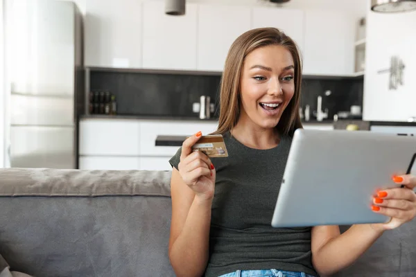 Sorrindo Jovem Mulher Sentada Sofá Casa Usando Tablet Computador Mostrando — Fotografia de Stock