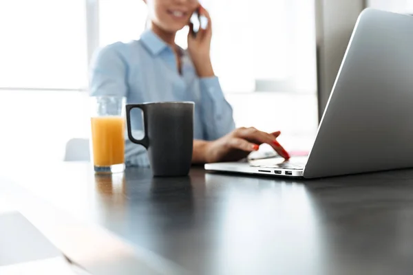 Jistý Podnikatel Pracuje Notebooku Když Seděl Kuchyni Mluvit Mobilním Telefonu — Stock fotografie