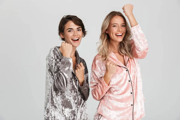 Twee Vrolijke Meisjes Dragen Van Pyjama Permanent Geïsoleerde Grijze Achtergrond — Stockfoto