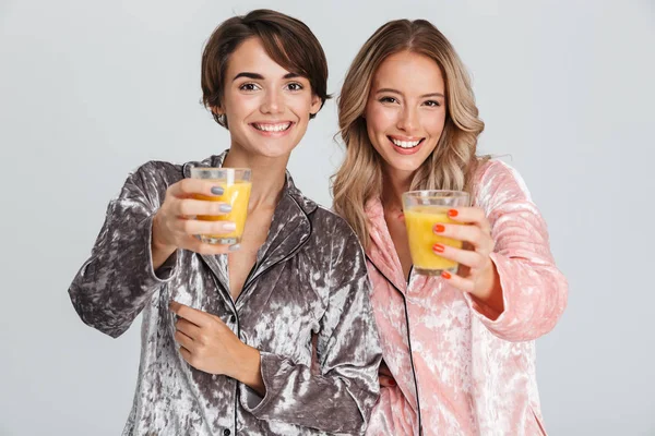 Duas Meninas Bonitas Vestindo Pijama Isolado Sobre Fundo Cinza Beber — Fotografia de Stock
