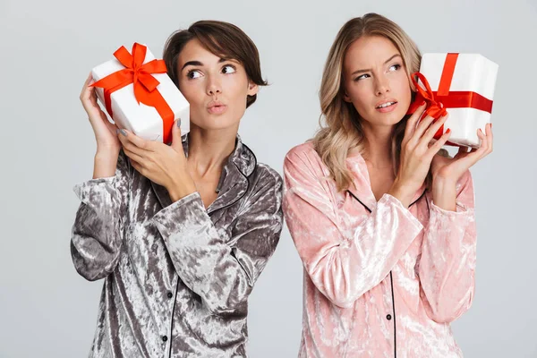 Дві Красиві Дівчата Піжамі Ізольовані Сірому Фоні Тримаючи Подарункові Коробки — стокове фото