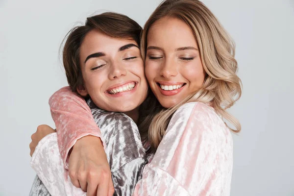 Duas Meninas Bonitas Vestindo Pijama Isolado Sobre Fundo Cinza Abraçando — Fotografia de Stock