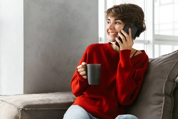 Sorrindo Jovem Mulher Vestindo Suéter Relaxante Sofá Casa Beber Café — Fotografia de Stock