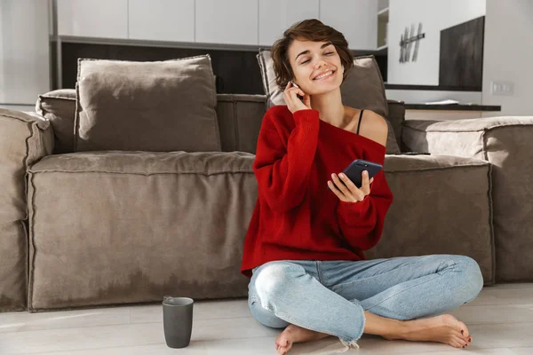 Smiling Young Woman Earphones Wearing Sweater Relaxing Couch Home Drinking — Stock Photo, Image