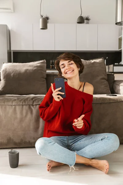 Sorrindo Jovem Mulher Fones Ouvido Vestindo Suéter Relaxante Sofá Casa — Fotografia de Stock