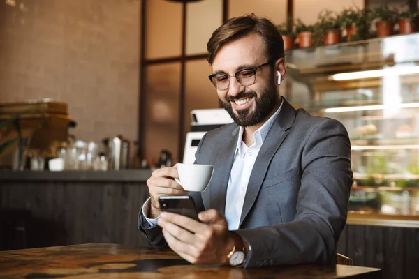 Щасливий Бізнесмен Каву Сидячи Столом Кафе Тримаючи Мобільний Телефон — стокове фото