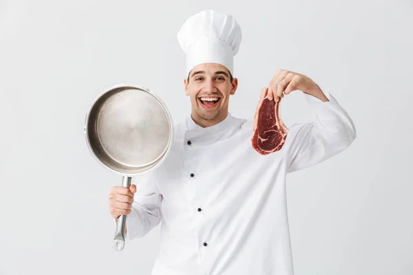 Cheerful Cozinheiro Chef Vestindo Uniforme Mostrando Carne Crua Segurando Frigideira — Fotografia de Stock