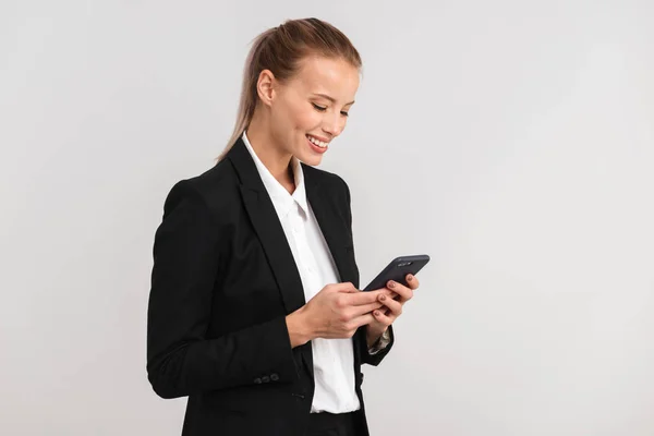 Sonriente Mujer Negocios Rubia Pie Aislada Sobre Fondo Gris Utilizando — Foto de Stock