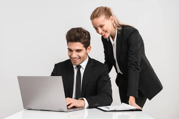 Lächelndes Geschäftspaar Anzügen Vor Grauem Hintergrund Das Mit Laptop Arbeitet — Stockfoto