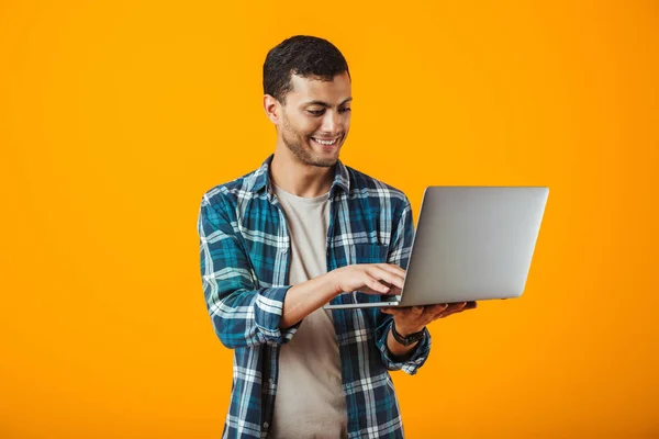 Dizüstü Bilgisayar Holding Neşeli Genç Adam Turuncu Arka Plan Üzerinde — Stok fotoğraf