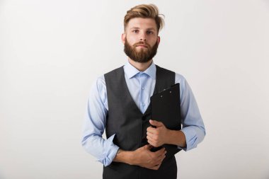 Yakışıklı bir genç sakallı adam Pano holding beyaz duvar arka plan üzerinde izole ayakta görüntüsünü.