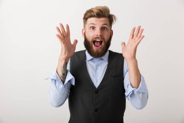 Beyaz duvar arka plan üzerinde izole bir yakışıklı şok heyecanlı Genç sakallı adam ayakta görüntüsünü.