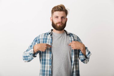 Kendisi de parmak işaret ekose gömlek beyaz arka plan üzerinde izole ayakta endişeli sakallı adam giymiş