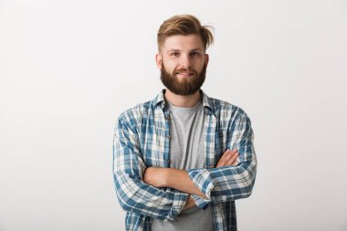 Mutlu sakallı adam beyaz arka plan üzerinde katlanmış silah izole ayakta ekose gömlek giymiş