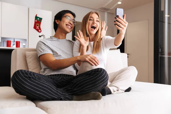 Alegre Joven Pareja Tomando Selfie Mientras Sentado Sofá Casa —  Fotos de Stock