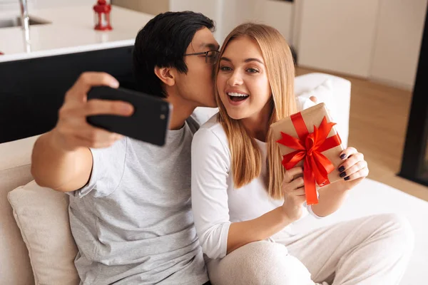 Fröhliches Junges Paar Das Hause Auf Einer Couch Sitzt Ein — Stockfoto