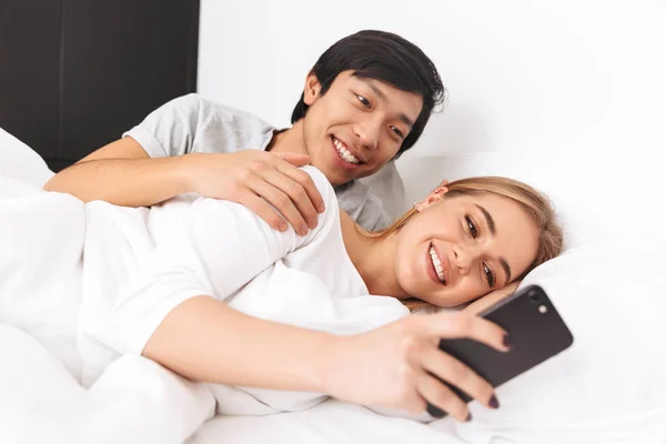 Красива Молода Пара Лежить Ліжку Молода Дівчина Використовує Мобільний Телефон — стокове фото