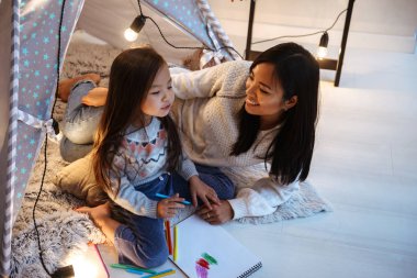 Katta eğleniyor küçük kızıyla birlikte mutlu bir genç Asyalı kadın fotoğrafı. Noel kavramı.