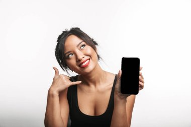 Boş ekran cep telefonu gösterilen beyaz arka plan üzerinde izole gülümseyen Genç Asyalı kadın
