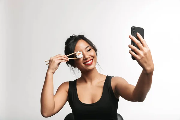 Alegre Jovem Ásia Mulher Comer Sushi Com Pauzinhos Isolado Sobre — Fotografia de Stock