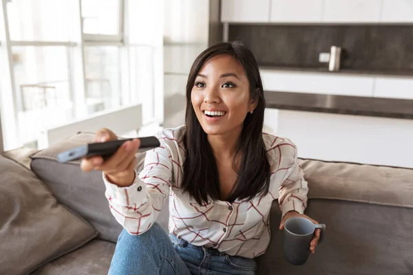 Photo Positive Asian Woman 20S Holding Remote Control Watching While — Stock Photo, Image
