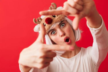 Heyecanlı bir genç şok kadın görüntüsünü kırmızı duvar arka plan üzerinde izole poz karnaval yılbaşı kostüm giymiş.