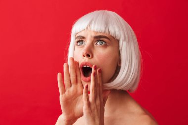 Görüntü güzel bir kadının çığlık Beyaz peruk takmış kırmızı duvar arka plan üzerinde izole.