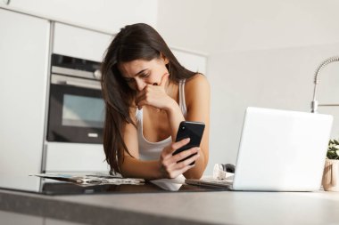 Cep telefonuyla sohbet mutfak ayakta günlük sabah rutin inanılmaz bir mutlu sağlıklı kadın görüntüsünü.