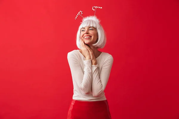 stock image Image of a young happy woman dressed in carnival christmas costume posing isolated over red wall background.