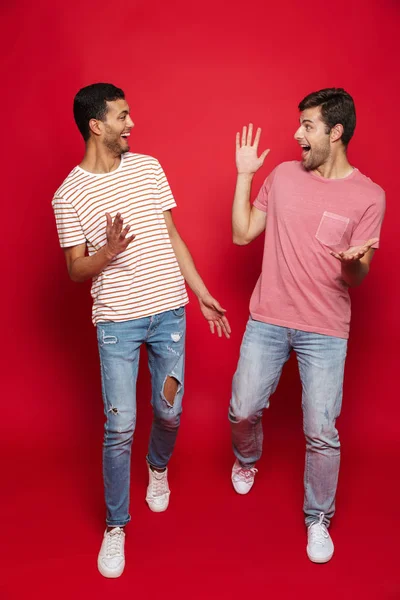 Dos Alegres Amigos Hombres Caminando Aislados Sobre Fondo Rojo — Foto de Stock