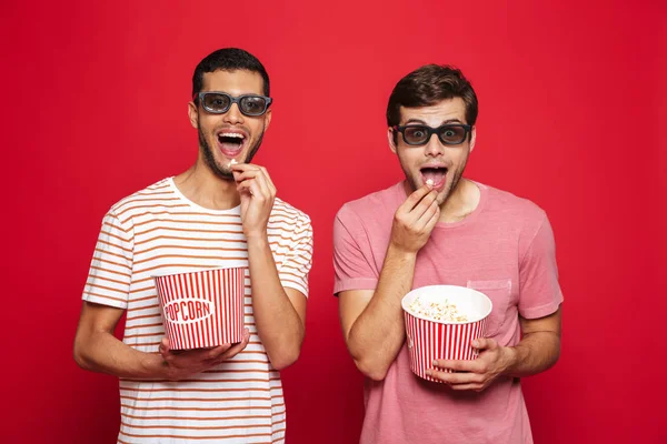 Dois Jovens Alegres Isolados Sobre Fundo Vermelho Comendo Pipocas Vestindo — Fotografia de Stock