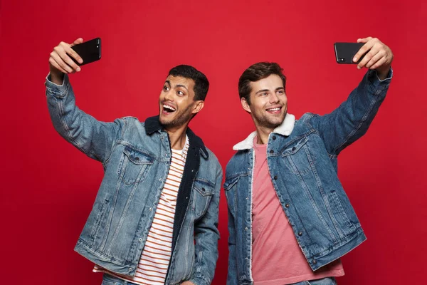 Two Cheerful Young Men Standing Isolated Red Background Taking Selfie — Stock Photo, Image