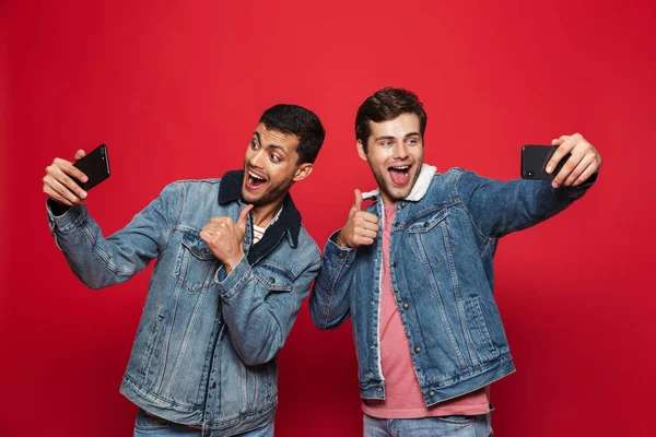 Dois Jovens Alegres Isolados Sobre Fundo Vermelho Tirando Uma Selfie — Fotografia de Stock