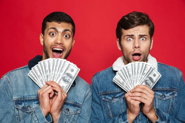 Twee Vrolijke Jonge Mannen Rode Achtergrond Geïsoleerd Staande Houden Geld — Stockfoto