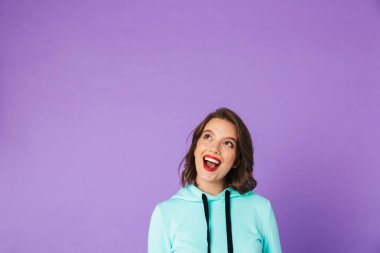 Heyecanlı bir güzel genç kadının poz görüntü izole mor arka duvarı.