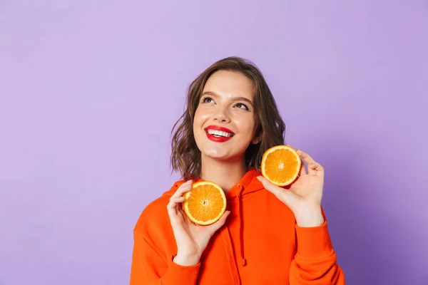 一个兴奋的美丽的年轻女子的形象 提出孤立在紫色背景墙举行橙色柑橘 — 图库照片