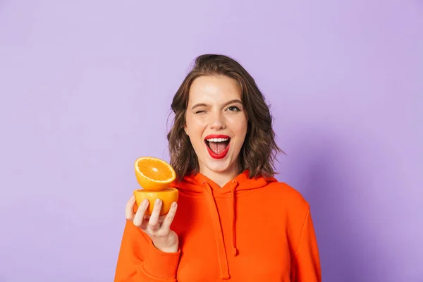 一个兴奋的美丽的年轻女子的形象 提出孤立在紫色背景墙举行橙色柑橘 — 图库照片