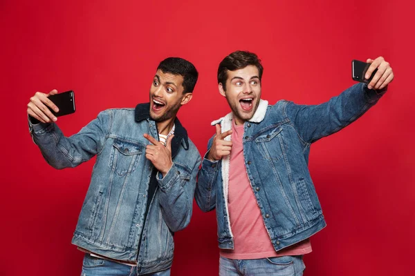 Dois Jovens Alegres Isolados Sobre Fundo Vermelho Tirando Uma Selfie — Fotografia de Stock