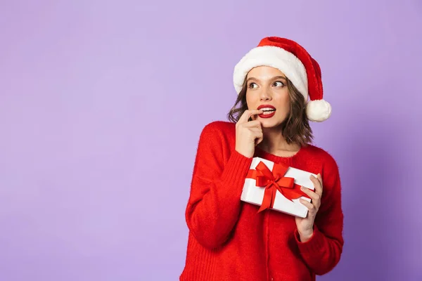 Leende Fundersam Ung Kvinna Som Bär Röd Jul Hatt Stående — Stockfoto