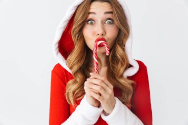 Noel şeker neşeli genç kız beyaz arka plan üzerinde izole ayakta yılbaşı elbisesi giyen davranır