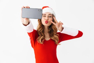Yılbaşı kostüm güzel bir duygusal kadın görüntüsünü almak bir selfie cep telefonu tarafından öpücükler üfleme.