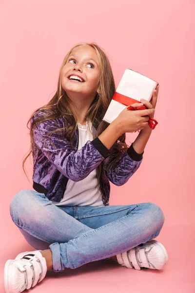 Pretty Little Girl Sitting Isolated Pink Background Holding Gift Box — Stock Photo, Image